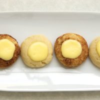 Cheesecake Thumbprint Cookies are soft cookies filled with sweet cheesecake. Roll them in cinnamon-sugar for a tasty variation.