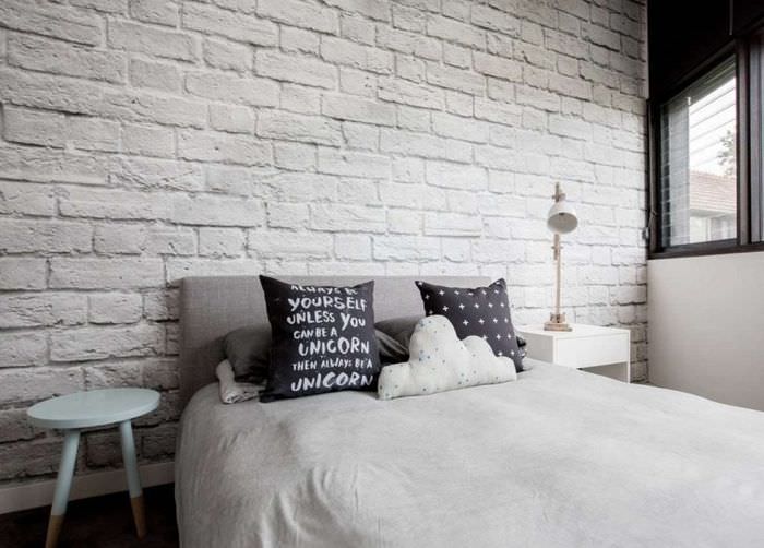 Кирпичная стена белоснежного цвета в спальне частного дома