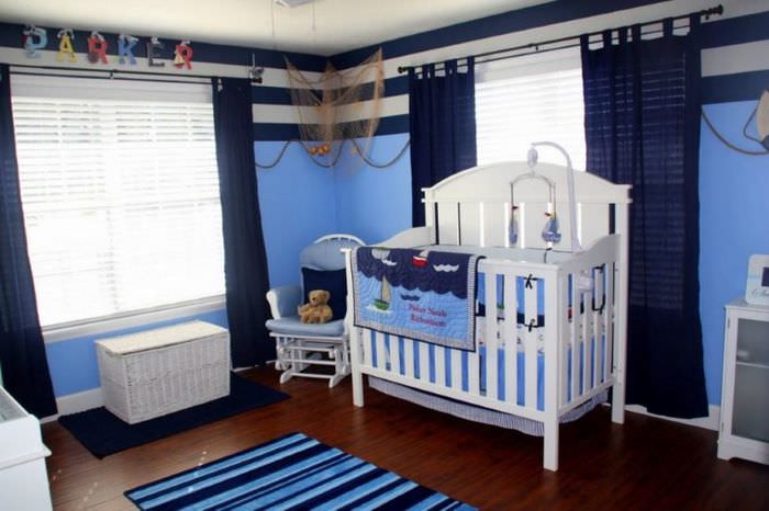 Белая кроватка для младенца в комнате с синими шторами